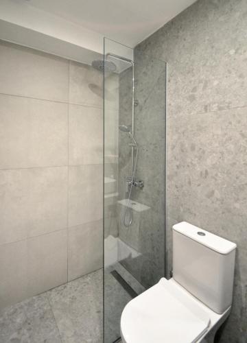 a bathroom with a toilet and a glass shower at Sea-duction Studios in Nea Iraklia