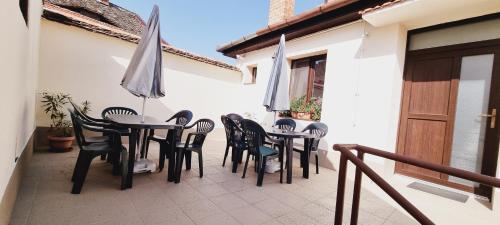 a patio with tables and chairs and an umbrella at Lindenhaus in Sibiu