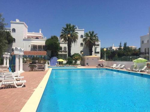 a large swimming pool in front of a building at Tavira Small cozy flat by the pool and by the sea in Tavira