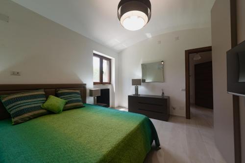 a bedroom with a green bed and a television at IL GIARDINO in Procida