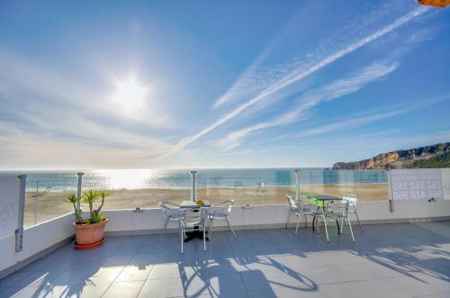 a balcony with chairs and a view of the beach at Apartamentos 7 Saias Marginal in Nazaré