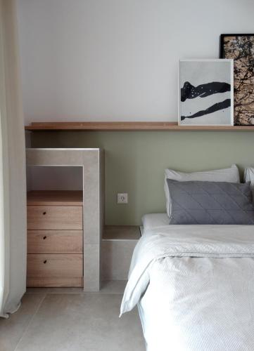 a bedroom with a bed and a wooden dresser at Sea-duction Studios in Nea Iraklia