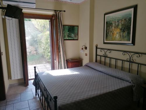 a bedroom with a bed and a sliding glass door at Locanda del Barone in Caramanico Terme