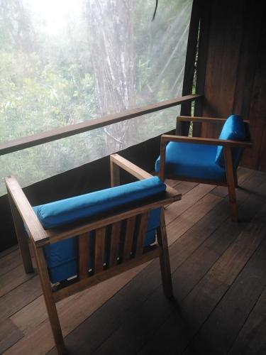 a bench with a blue cushion sitting in front of a window at Punta Brava in Nuquí