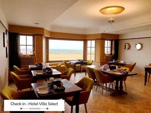 デ・パンネにあるHotel Villa Escaleのビーチの景色を望むレストラン(テーブル、椅子付)