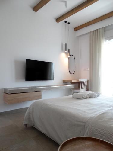 a bedroom with a bed and a tv on a wall at Sea-duction Studios in Nea Iraklia