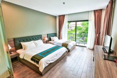 a hotel room with two beds and a balcony at KEP BAY HOTEL & RESORT in Kep