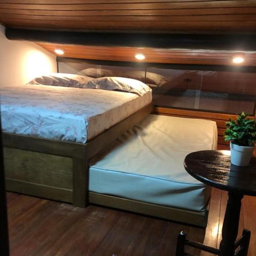 a bed sitting in a room with a table at WinterVille Gravatá 418 in Gravatá