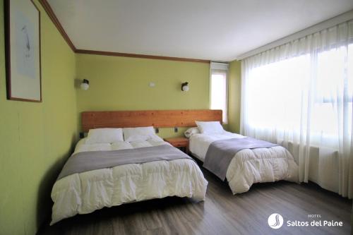a bedroom with a bed and a window at Hotel Saltos del Paine in Puerto Natales