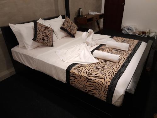 een bed met zebraprint-lakens en kussens erop bij W1 Ella in Ella