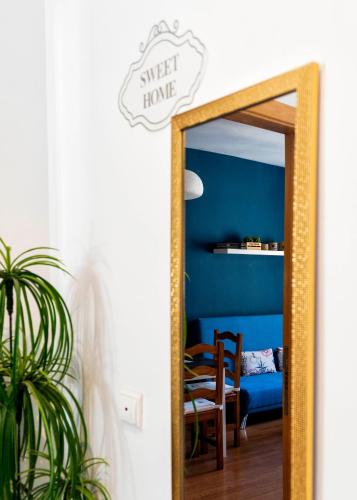 a mirror in a room with a blue wall at Apartamentos Turísticos Architettura Úbeda in Úbeda