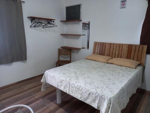 a small bedroom with a bed and a television at Kitnets Capri in Caraguatatuba