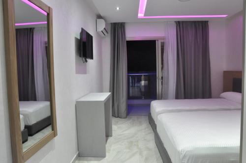 um quarto de hotel com duas camas e um espelho em Hôtel laluna bay em M'diq