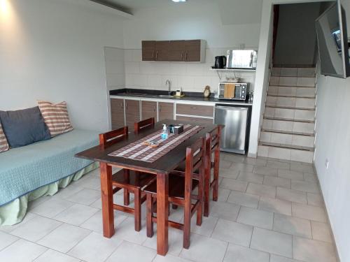 a kitchen with a table and chairs and a couch at Flamenco Bay Apartments in El Calafate