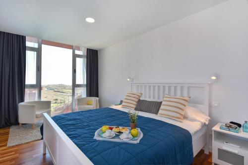 a bedroom with a bed with a tray of fruit on it at Eagle 8 by VillaGranCanaria in Las Palmas de Gran Canaria