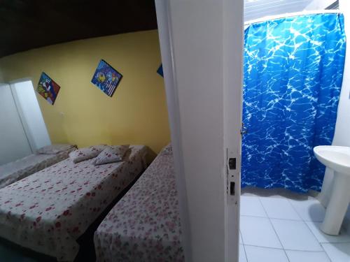 a bedroom with two beds and a sink at PousadaRecanto684Guarujá in Guarujá