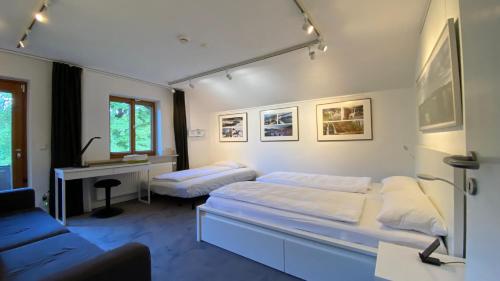 a bedroom with two beds and a desk in it at Pure Nature Munich - Alps in Fischbachau