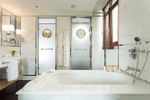 a white bath tub in a bathroom with a shower at Portrait Firenze - Lungarno Collection in Florence
