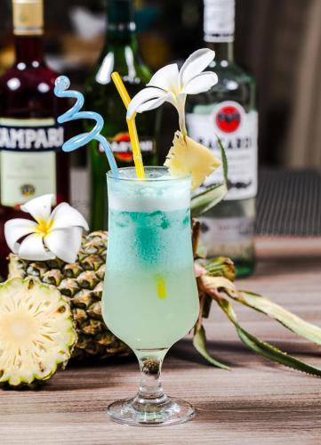 a drink in a glass with a flower on a table at KEP BAY HOTEL & RESORT in Kep