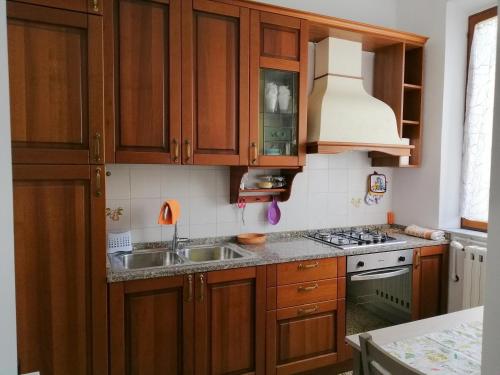 una cocina con armarios de madera y fregadero en Appartamento centralissimo a Casciana Terme en Casciana Terme
