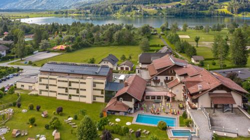 eine Luftansicht eines Resorts mit einem großen Gebäude in der Unterkunft Alpen Adria Hotel & Spa in Presseggersee