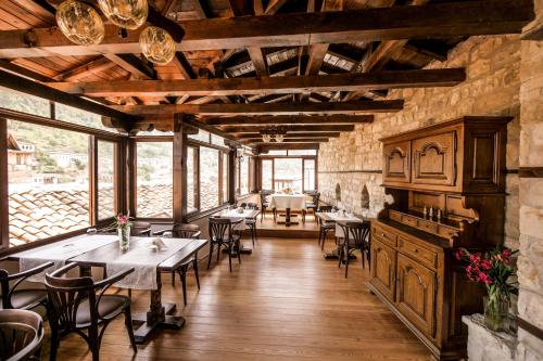 ein Restaurant mit Tischen und Stühlen in einem Zimmer in der Unterkunft Beratino Hotel in Berat