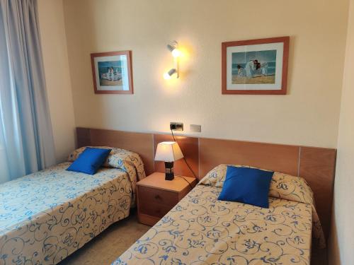 Habitación de hotel con 2 camas y almohadas azules en Mar Blau, en Puerto de Alcudia