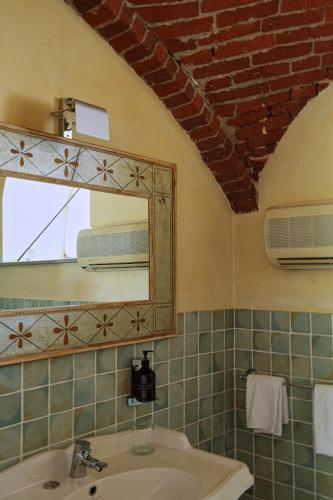 ein Badezimmer mit Waschbecken und Spiegel in der Unterkunft Tenuta La Cascinetta in Buriasco