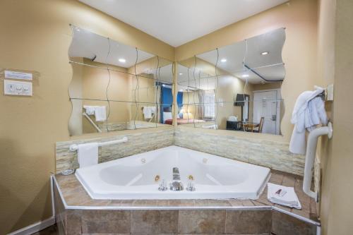 a bathroom with a tub and a large mirror at Knights Inn Trevose in Trevose