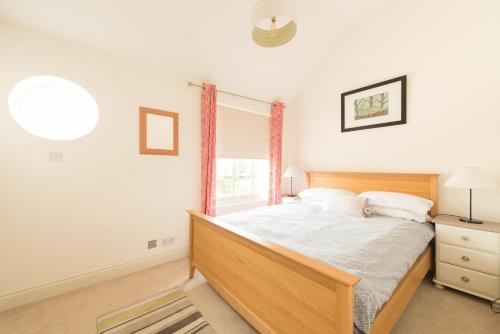 sypialnia z dużym łóżkiem i oknem w obiekcie My Place Go - Cirencester w mieście Cirencester