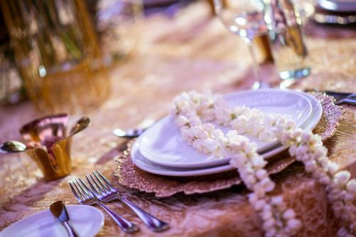 a table topped with plates and silverware with flowers on it at Crowne Plaza Doha - The Business Park by IHG in Doha