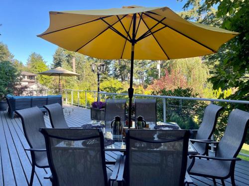 a table with a yellow umbrella on a deck at Kye Bay BnB - A Place to Breathe in Comox