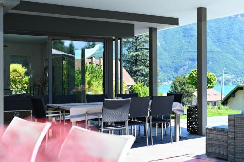 une salle à manger avec une table et des chaises sur un patio dans l'établissement Charming villa with pool lake view 10 minutes from the city center, à Sévrier