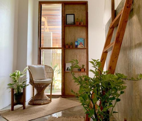 a room with a chair and a window with plants at Kaha Island Stay in Santa Monica