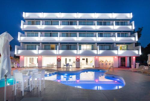 un hotel con piscina di fronte a un edificio di Typic Marina Playa - Adults Only a Baia di Sant'Antoni