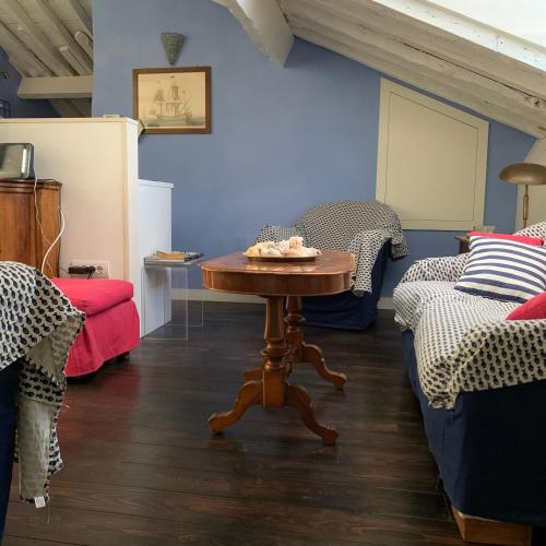 a room with two beds and a table in the middle at La Trabacca, attico nel pieno centro di Levanto in Levanto