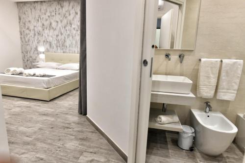 a bathroom with a bed and a sink and a mirror at VL Central Room in Olbia