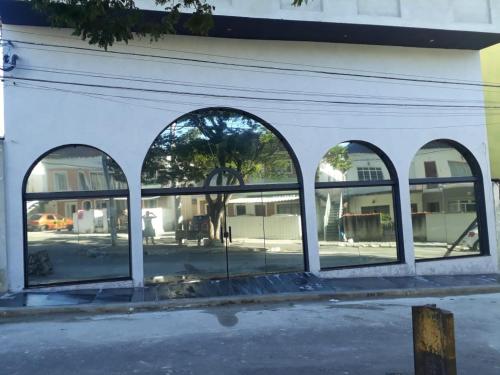 an empty building with three arched windows at Hotel Mamma Mia in Aparecida