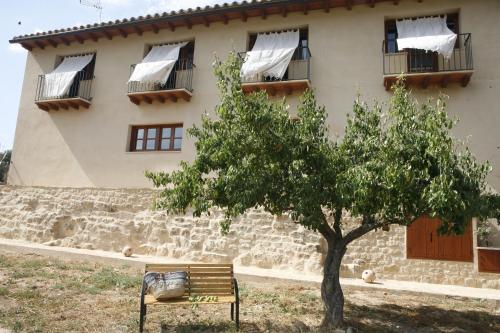a bench in front of a building with a tree at Hort de L'Aubert in Cretas