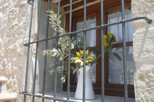 a white vase with yellow flowers on a window at Hort de L'Aubert in Cretas