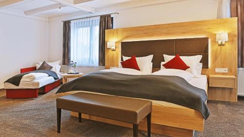 a hotel room with a large bed with red pillows at Hotel Restaurant Schiff in Kappel-Grafenhausen
