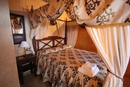 - une chambre avec un lit à baldaquin dans l'établissement Casa Rural Finca El Tornero, à Aracena