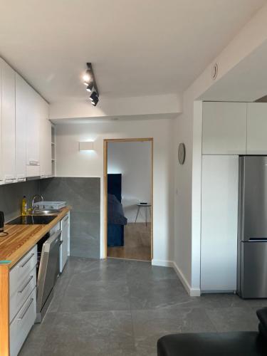 a kitchen with white cabinets and a stainless steel refrigerator at Na Pensjonatowej in Augustów