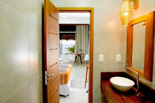 een badkamer met een wastafel en een spiegel bij VILLA ÁGUA DE COCO PREÁ in Prea