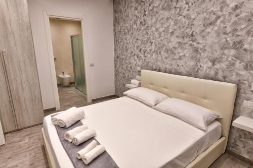 a bedroom with a white bed with towels on it at VL Central Room in Olbia