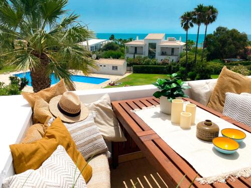 a table and chairs on a patio with a view of the ocean at Beach villa with ocean view and rooftop cinema in Guia