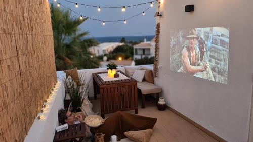 a patio with a table and chairs and lights at Beach villa with ocean view and rooftop cinema in Guia