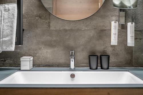 a white sink in a bathroom with a mirror at Hotel Tyrolerhof in Sölden