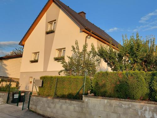 a house with a hedge in front of it at Privatzimmer Roland in Hutten