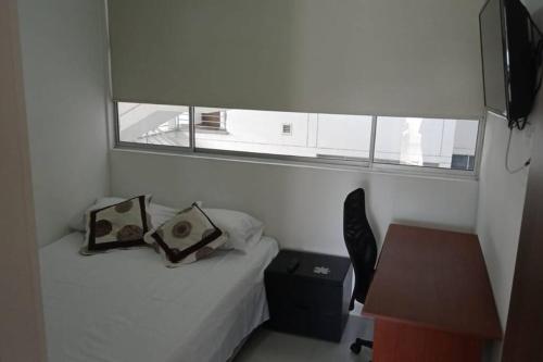 a small bedroom with a bed and a window at Hermoso apartamento, cerca Hospital Internacional in Floridablanca